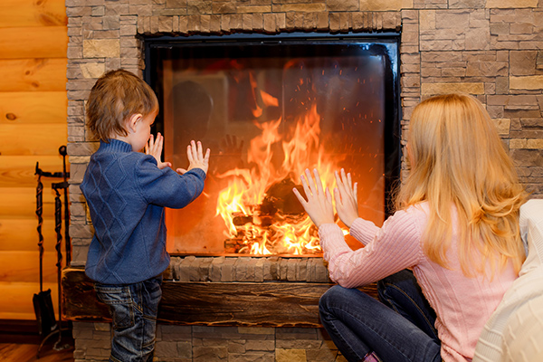 Family heating their home with a fireplace.