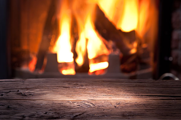 View of a fireplace over an old wooden table.