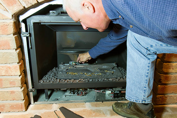 A man showing how to close a fireplace for the season