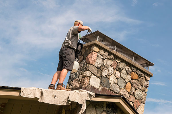 Doctor Flue chimney sweep cleaning a chimney interior.