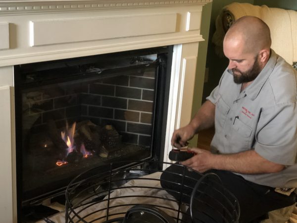 Kevon Binder of Doctor Flue servicing a customer's gas fireplace.