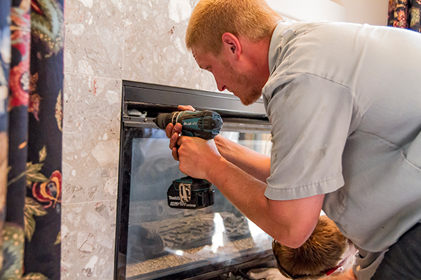 A Doctor Flue technician converting a wood fireplace to gas.