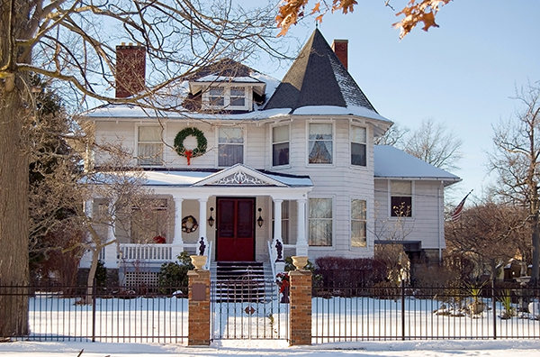 A stately Victorian home is dusted with snow at Christmastime. These historic homes can be plagued with old chimney problems