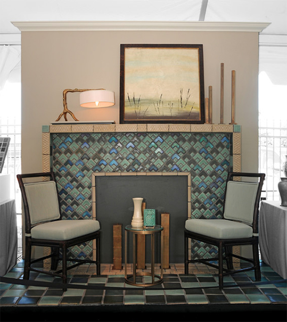 Earthy fireplace design with muted blue, green, and gray tile surround and a beige stone mantel with blue corner accents.