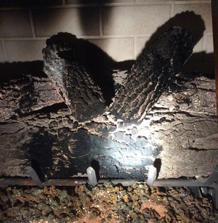 Gas log fireplace in need of repair, before service