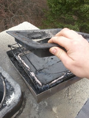 Technician repairing a damaged chimney cap