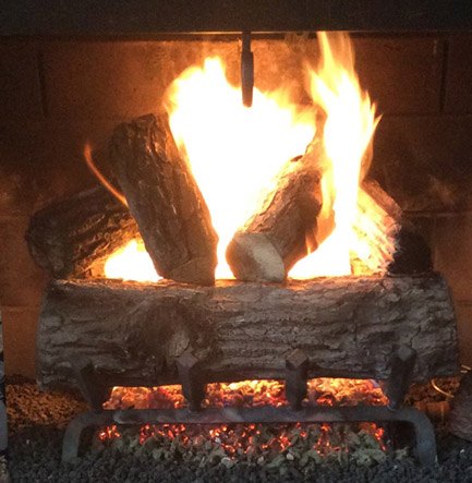 The same gas log fireplace after repair, lit and working