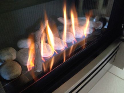 Gas fireplace burning over decorative stones
